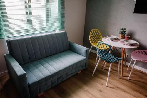 a couch in a room with a table and chairs at VS Apartments - apartament nr 33 in Łódź