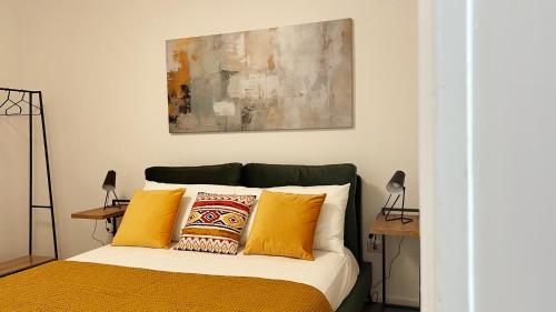 a bedroom with a bed with yellow pillows at 169Home in Catania