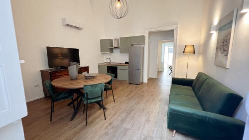 a living room with a table and a green couch at 169Home in Catania
