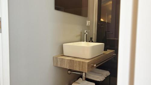 a bathroom with a white sink on a wooden counter at 169Home in Catania