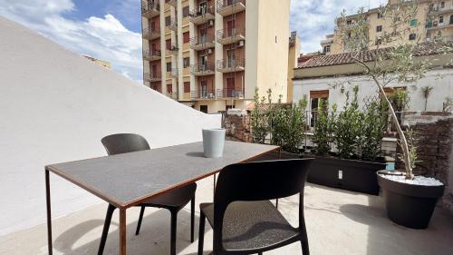 a table and chairs on a balcony with a building at 169Home in Catania