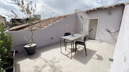 a patio with a table and chairs on a house at 169Home in Catania