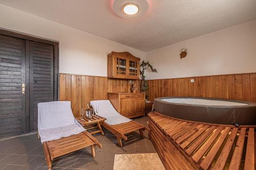 un ampio bagno con vasca e due sedie di Vineyard Cottage Krivic - Happy Rentals a Trebelno