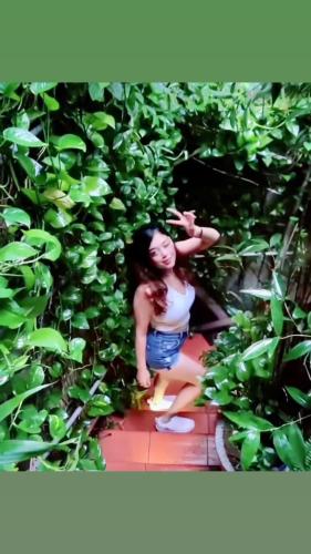 a woman is standing in a bush at Old House Homestay in Hanoi