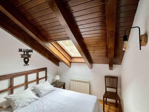 um quarto com uma cama e um tecto de madeira em BPIRINEOS-Gorgütes em Benasque