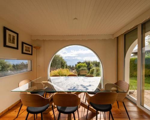 a dining room with a table and chairs and a window at CHALET du GOLF CRANS MONTANA in Crans-Montana