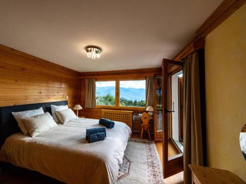 a bedroom with a large bed and a large window at CHALET du GOLF CRANS MONTANA in Crans-Montana