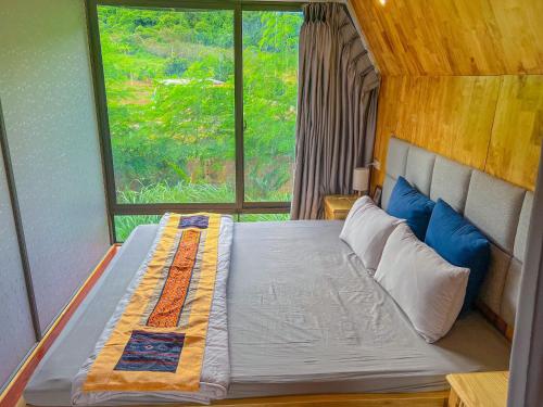 Cama grande en habitación con ventana en Vườn An nhiên Mộc Châu, en Mộc Châu