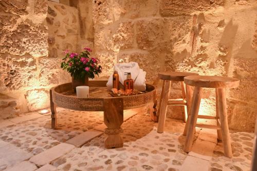 a table and two stools in a room at Ca Sana Teulada Moraira, Grupo Terra de Mar, alojamientos con encanto in Moraira