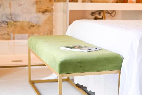 a green bench with a book on top of it at Ca Sana Teulada Moraira, Grupo Terra de Mar, alojamientos con encanto in Moraira