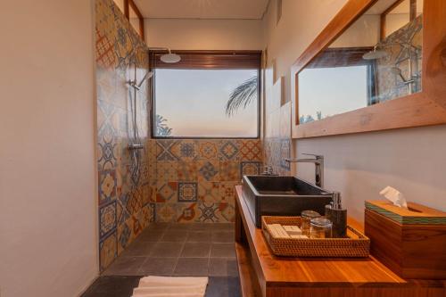baño con lavabo y ventana en Green Sala Villa en Ubud