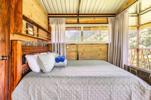 um quarto com uma cama num chalé de madeira em Hotel Rivel - Restaurant & Nature Retreat em Turrialba