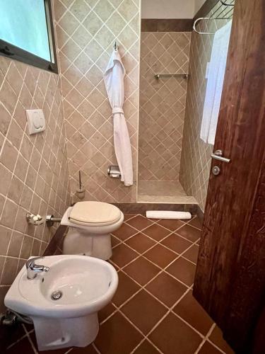 a bathroom with a toilet and a sink at Hotel Club Dongwe in Pingwe
