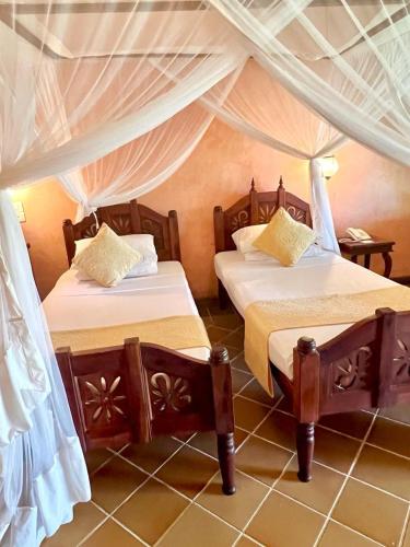 a bedroom with two beds in a room at Hotel Club Dongwe in Pingwe
