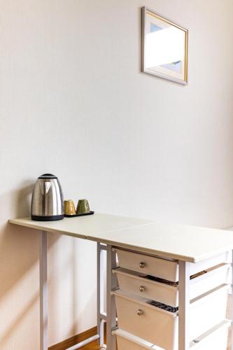 a white desk with a tea kettle on top at 博多駅東貸切Hakataekihigashi Apartment LOFT付き 敷地内駐車場 地下鉄5分国際線博多駅 in Fukuoka