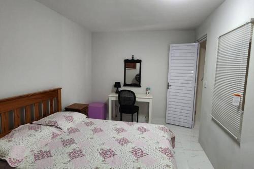 een slaapkamer met een bed, een bureau en een stoel bij Duplex com 02 suítes, mobiliado e reformado em Vilas do Atlântico in Lauro de Freitas