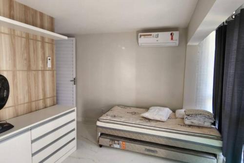 een kleine slaapkamer met een bed in een kamer bij Duplex com 02 suítes, mobiliado e reformado em Vilas do Atlântico in Lauro de Freitas