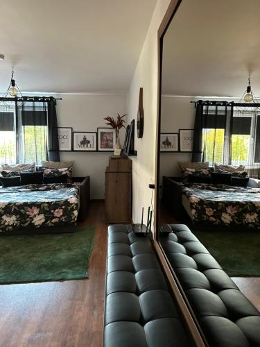 um quarto com duas camas e um espelho grande em OzolApart em Jēkabpils