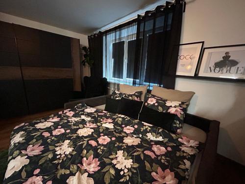 a bedroom with a bed with a floral comforter at OzolApart in Jēkabpils