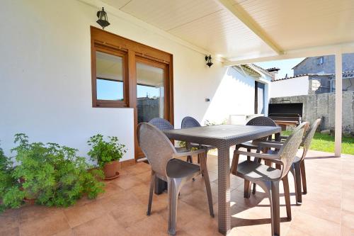 una mesa y sillas en el patio de una casa en GALIHOST - Casa Los Manolos en Vilanova de Arousa, en Villanueva de Arosa