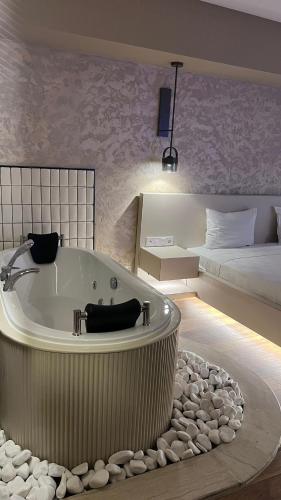 a large bathroom with a tub and a bed at Avwan Hotel Çiğli in İzmir
