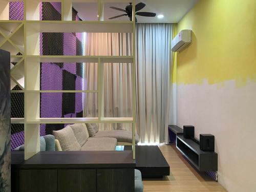 a living room with a couch and a ceiling fan at The Floorspace DeLoft Emporium Duplex Apartment in Kuching