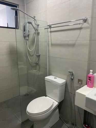 a bathroom with a shower and a toilet and a sink at The Floorspace DeLoft Emporium Duplex Apartment in Kuching
