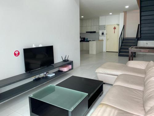 a living room with a couch and a flat screen tv at The Floorspace DeLoft Emporium Duplex Apartment in Kuching
