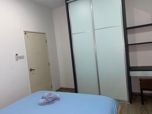 a pair of slippers sitting on a bed in a room at The Floorspace DeLoft Emporium Duplex Apartment in Kuching