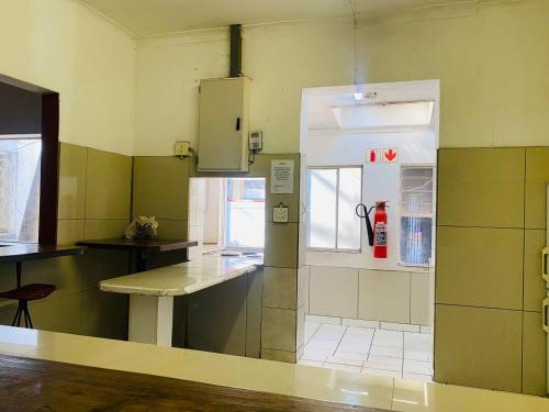 eine leere Küche mit einem Tisch und einem Fenster in der Unterkunft Rosebank Hostel in Johannesburg