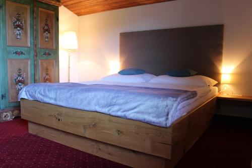 a bedroom with a large bed with a wooden headboard at Vorderweinaugut in Annaberg im Lammertal