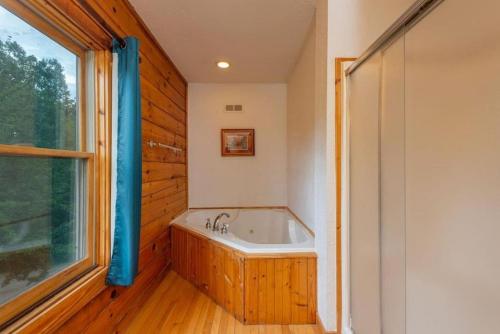a bath tub in a bathroom with a window at Gorgeous Mountain View Cabin on 12 Acres in Candler