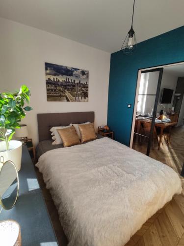 sypialnia z dużym łóżkiem i niebieską ścianą w obiekcie Warszawa - Apartament Chomikówka w Warszawie