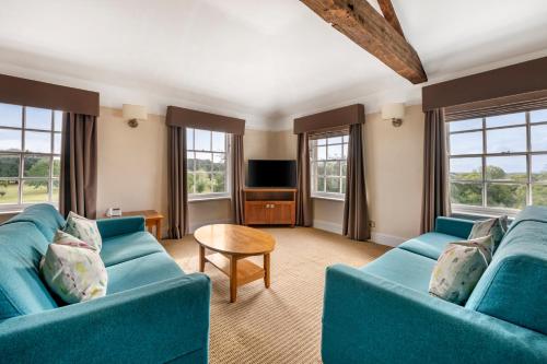 a living room with two blue couches and a table at Wychnor Park Country Club in Barton under Needwood