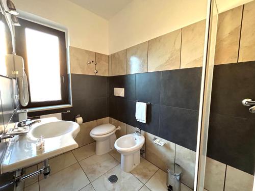 a bathroom with a toilet and a sink and a shower at Hotel Park in Rossano