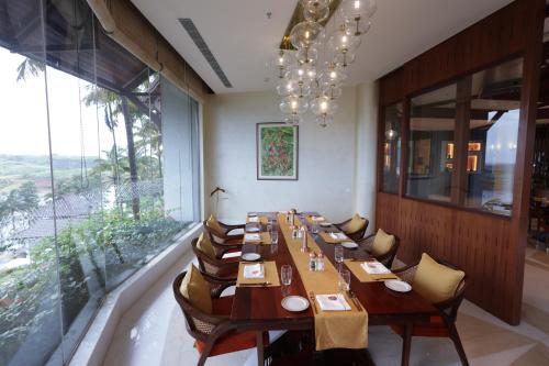 a large dining room with a long table and chairs at Taj Wayanad Resort & Spa, Kerala in Wayanad
