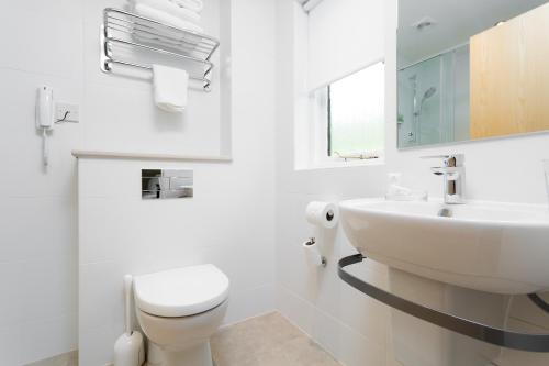 a white bathroom with a sink and a toilet at Wychnor Park Country Club in Barton under Needwood