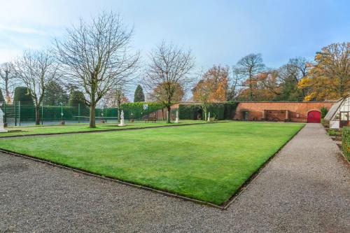 a large grassy yard with a building and trees at Wychnor Park Country Club in Barton under Needwood
