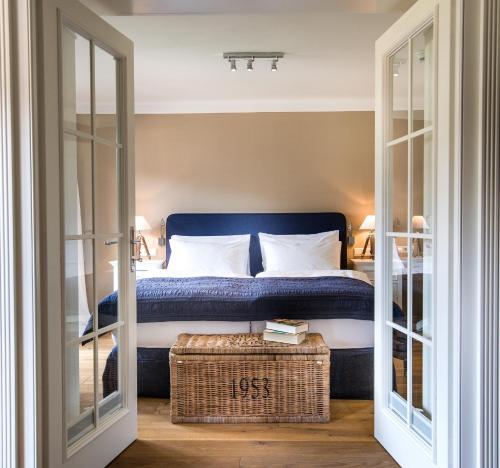a bedroom with a bed with a wicker trunk in front at Gut Weissenhof in Radstadt