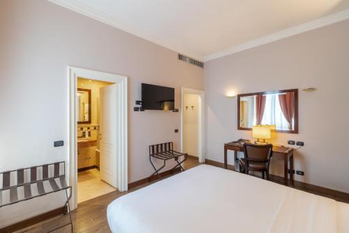 a bedroom with a bed and a desk and a table at Allegroitalia San Gallo Firenze in Florence