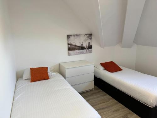 Habitación pequeña con 2 camas y paredes blancas. en Lovely 2-bedroom apartment in the heart of chelmsford, en Chelmsford