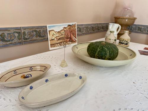 a table with two plates and a watermelon on it at Villa Vittoria in Matera