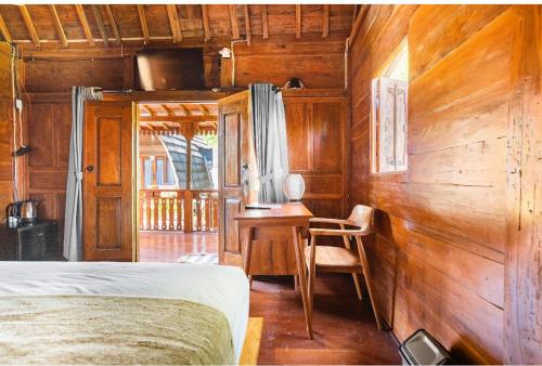 a bedroom with a bed and a desk and a table at Pondok chesia homestay in Canggu