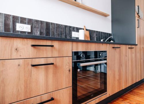 La cuisine est équipée d'armoires en bois et d'un four noir. dans l'établissement Les Balcons de Kéréon, à Quimper
