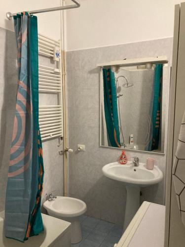 a bathroom with a sink and a toilet and a mirror at Casa vacanze Il Gianduiotto in Turin