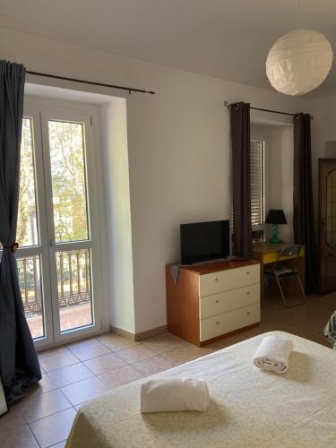 1 dormitorio con 1 cama, TV y ventana en Casa vacanze Il Gianduiotto en Turín