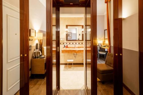 a room with a kitchen and a living room with a mirror at Allegroitalia San Gallo Firenze in Florence