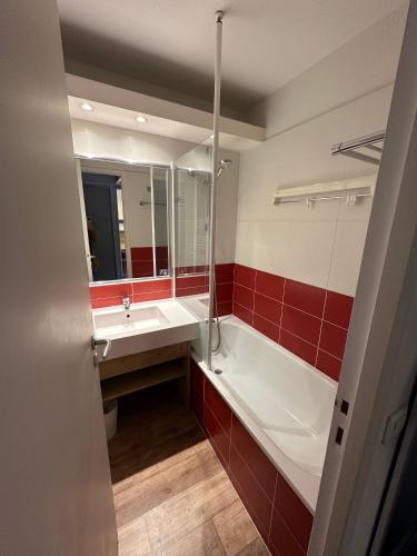 une salle de bain avec une baignoire, un lavabo et un miroir dans l'établissement Ski-in ski-out 1 bed, La Tania, à Courchevel