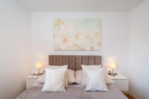 sypialnia z łóżkiem z białymi poduszkami i 2 lampami w obiekcie Skyline Luxe w mieście Zadar