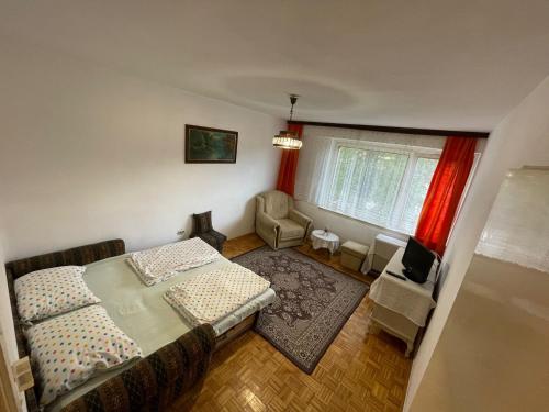 a bedroom with a bed and a chair and a window at Bronze Apartment in Sarajevo